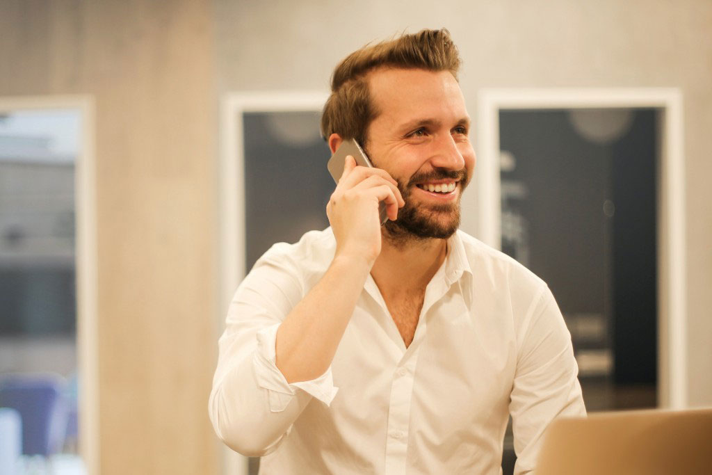 Gestor de lavado de imagen digital hablando por teléfono y sonriendo. 